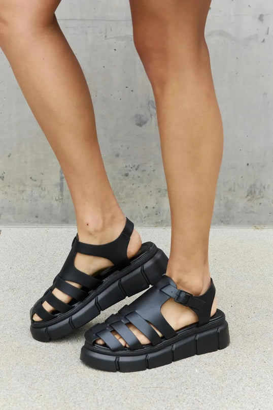 Sandalias elegantes de plataforma con tiras en forma de jaula de piel sintética negra