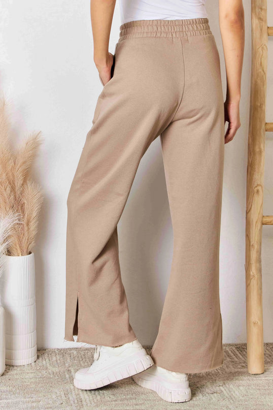 Pantalones elegantes de salón con pernera ancha, aberturas y cinturilla ancha